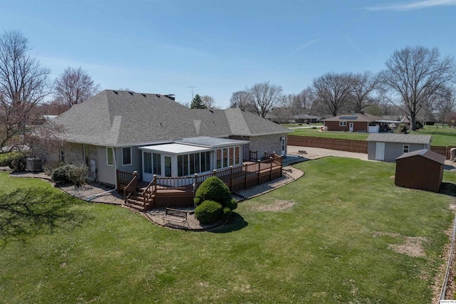 1501 Gayla Dr, Quincy, IL 62305 - back of house featuring a shed, a deck, a shingled roof, and a sunroom