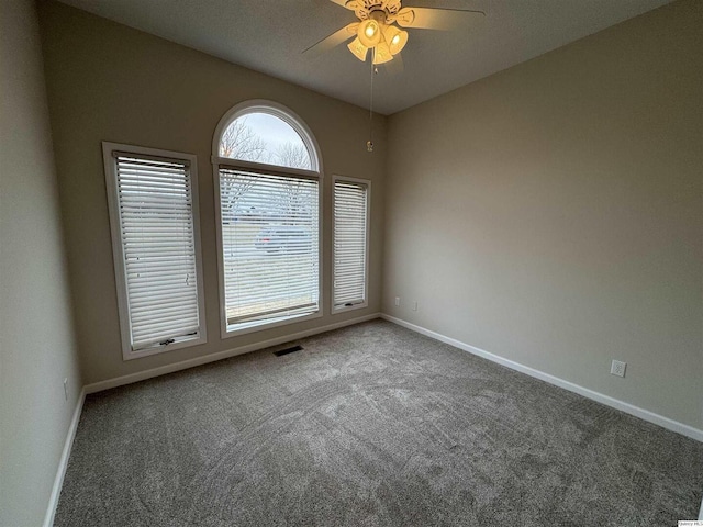 empty room featuring ceiling fan and carpet