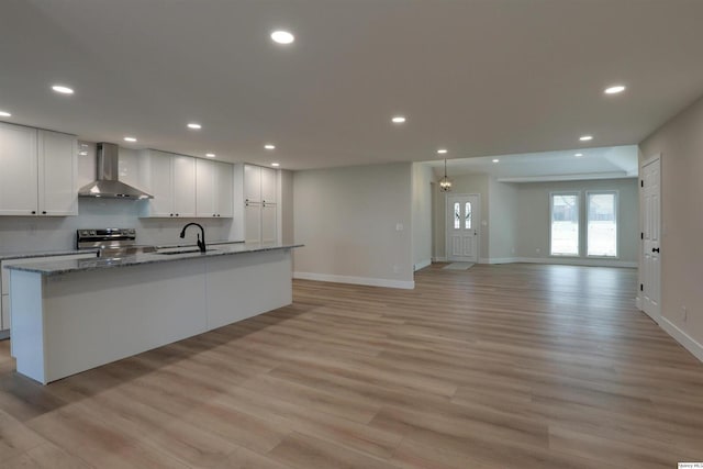 1501 Gayla Dr, Quincy, IL 62305 - kitchen featuring wall chimney range hood, stainless steel range with electric stovetop, light wood-style flooring, a kitchen island with sink, and recessed lighting