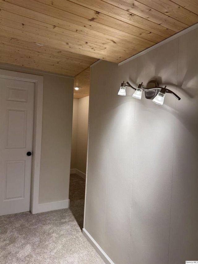 spare room featuring baseboards, wooden ceiling, and light colored carpet