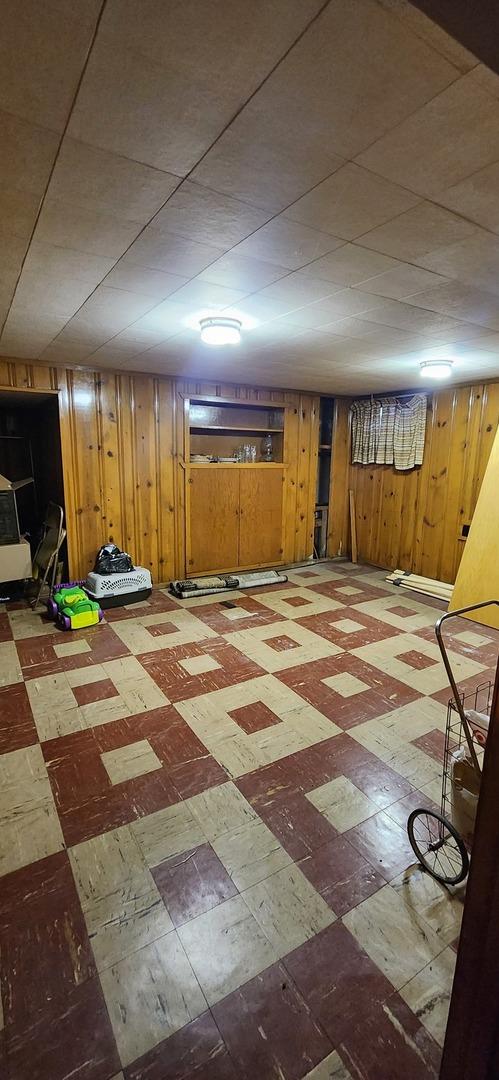 finished below grade area featuring wood walls and tile patterned floors