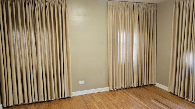 spare room featuring light wood-style flooring and baseboards