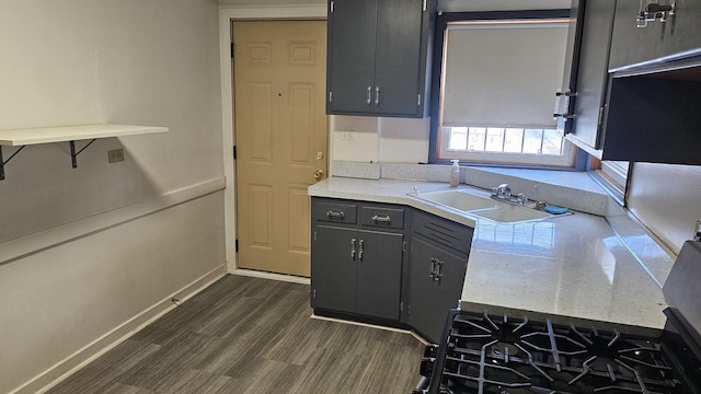 kitchen with baseboards, dark wood-style flooring, light countertops, gray cabinetry, and a sink