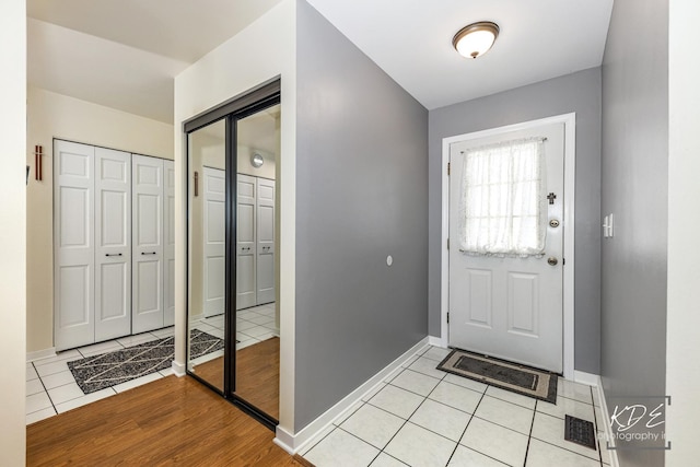 foyer entrance featuring baseboards and light tile patterned floors