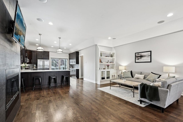 living room with dark wood-type flooring and a fireplace