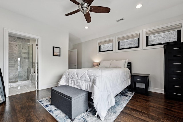 bedroom featuring multiple windows, ensuite bathroom, dark wood-type flooring, and ceiling fan