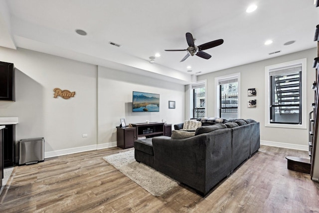 living room featuring wood-type flooring and ceiling fan