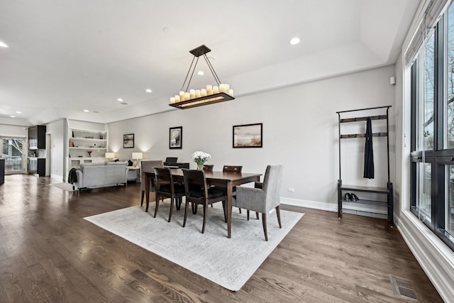 dining space featuring a notable chandelier and dark hardwood / wood-style floors