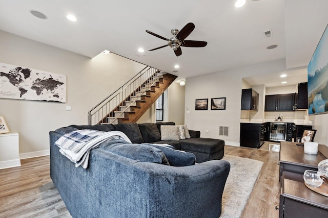 living room featuring wine cooler, light hardwood / wood-style flooring, and ceiling fan