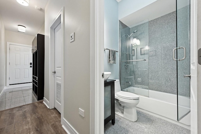 full bathroom featuring vanity, wood-type flooring, shower / bath combination with glass door, and toilet