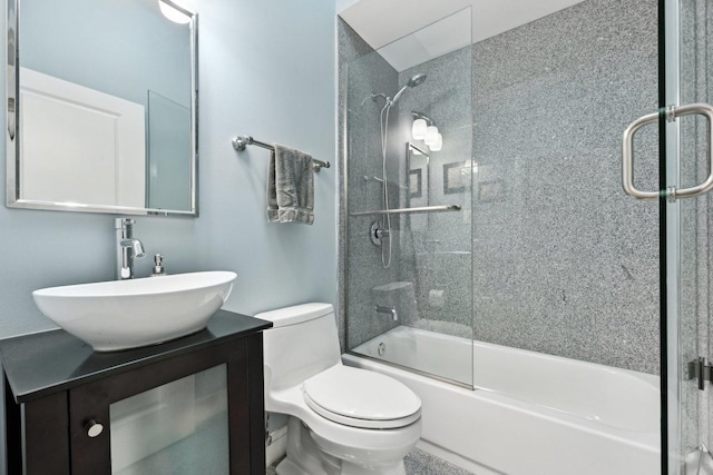 full bathroom featuring enclosed tub / shower combo, vanity, and toilet