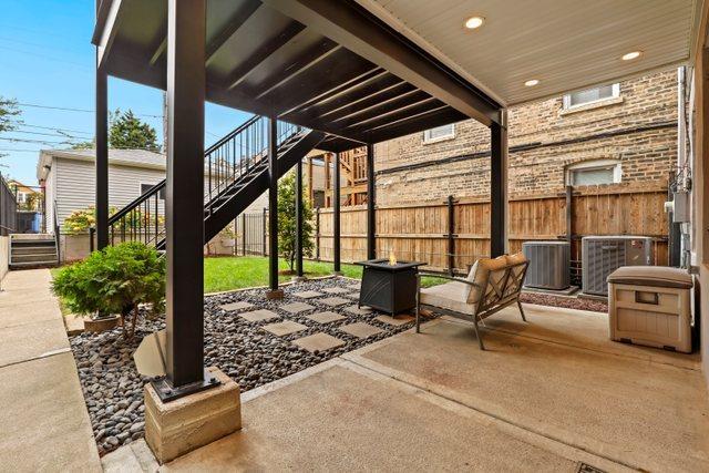 view of patio / terrace featuring central air condition unit and an outdoor fire pit