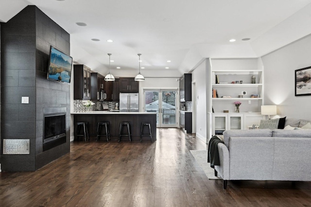 living room featuring dark hardwood / wood-style flooring, a fireplace, and built in features