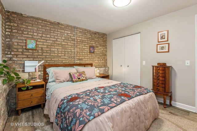 bedroom featuring a closet, baseboards, and wood finished floors