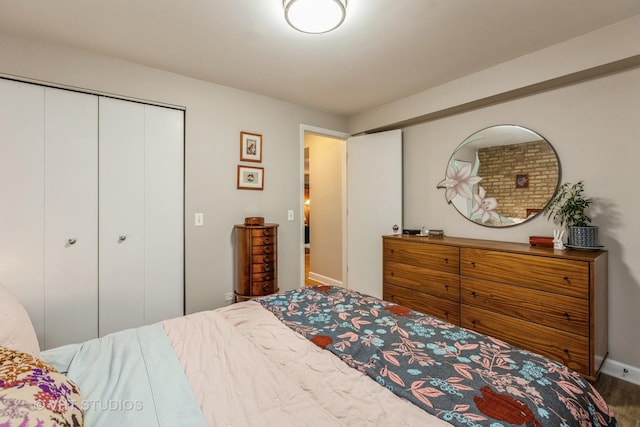 bedroom featuring a closet, baseboards, and wood finished floors