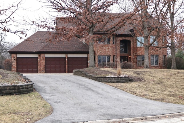 view of front of home featuring a shingled roof, brick siding, an attached garage, and aphalt driveway