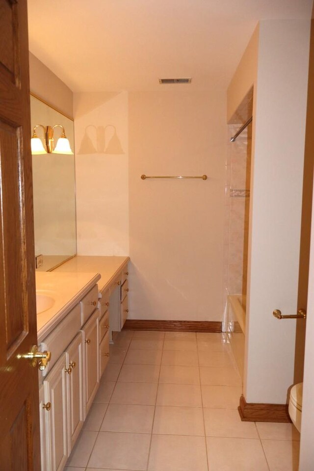 full bathroom featuring vanity, tiled shower / bath, tile patterned floors, and toilet