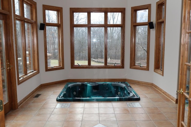 bathroom featuring a washtub, plenty of natural light, and tile patterned floors