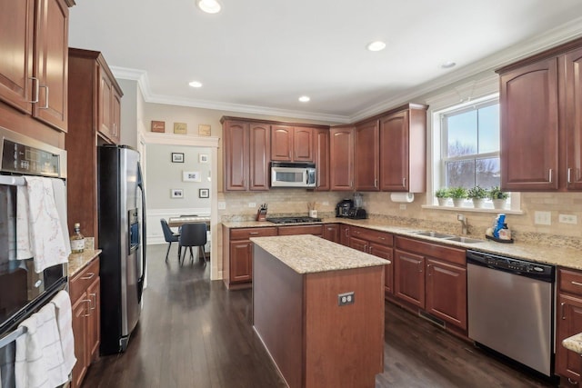 kitchen featuring appliances with stainless steel finishes, sink, a kitchen island, and dark wood-type flooring