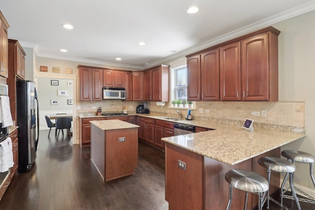 kitchen featuring a center island, stainless steel appliances, dark wood-type flooring, kitchen peninsula, and light stone countertops