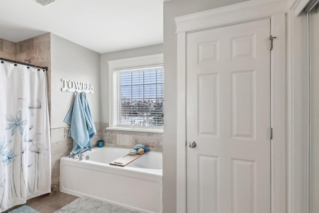 bathroom with tile walls and shower with separate bathtub