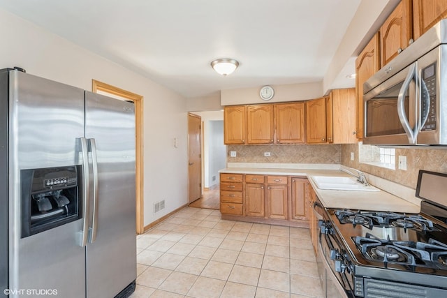 kitchen with light tile patterned flooring, appliances with stainless steel finishes, sink, and backsplash