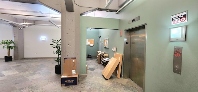 below grade area featuring baseboards and elevator