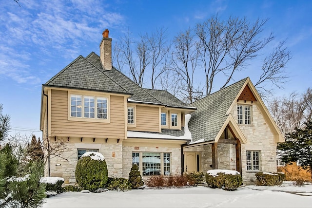 exterior space featuring stone siding and a chimney