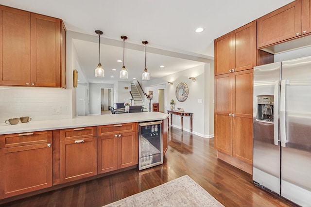 kitchen featuring brown cabinetry, wine cooler, light countertops, and stainless steel refrigerator with ice dispenser