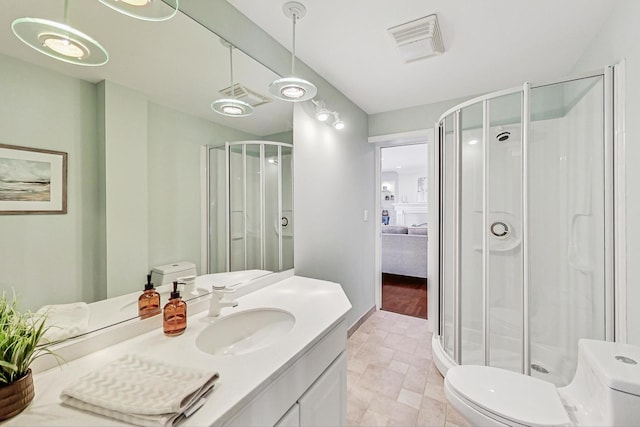 full bathroom featuring toilet, a stall shower, visible vents, and vanity