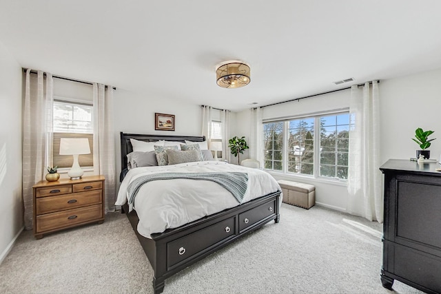 bedroom featuring baseboards, visible vents, and light colored carpet