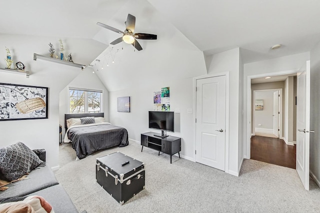 bedroom with a ceiling fan, light carpet, vaulted ceiling, and baseboards