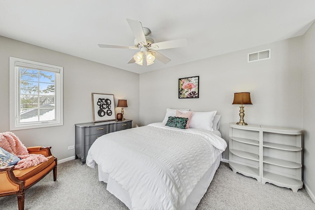 bedroom featuring baseboards, visible vents, a ceiling fan, and light colored carpet