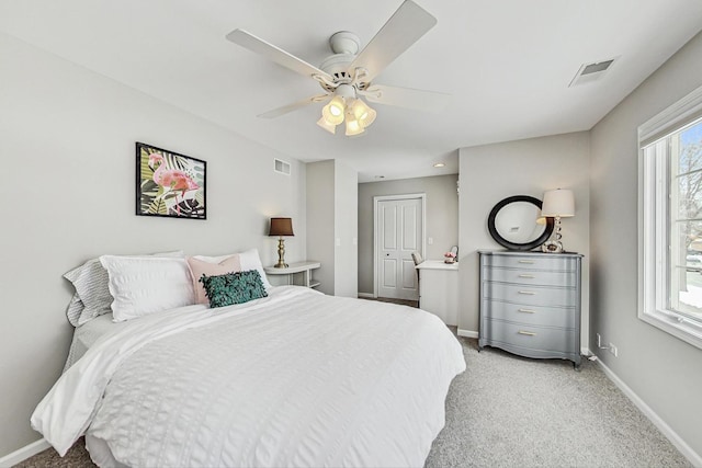 bedroom featuring baseboards, visible vents, a ceiling fan, and light colored carpet