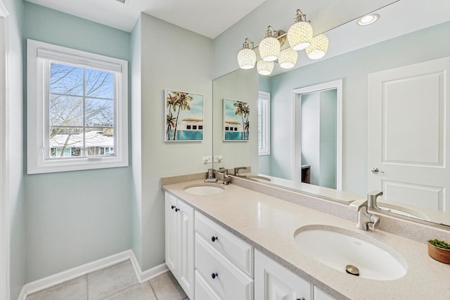 bathroom featuring tile patterned floors, a sink, baseboards, and double vanity