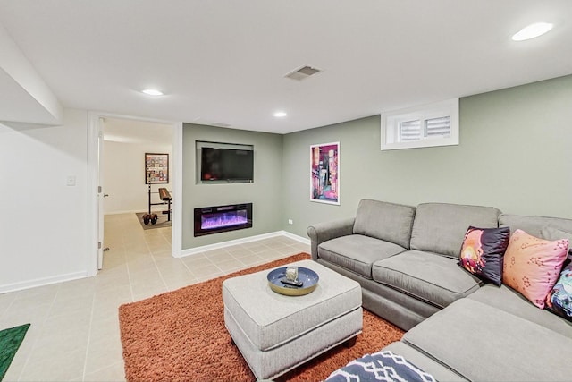 living area featuring light tile patterned floors, recessed lighting, visible vents, a glass covered fireplace, and baseboards