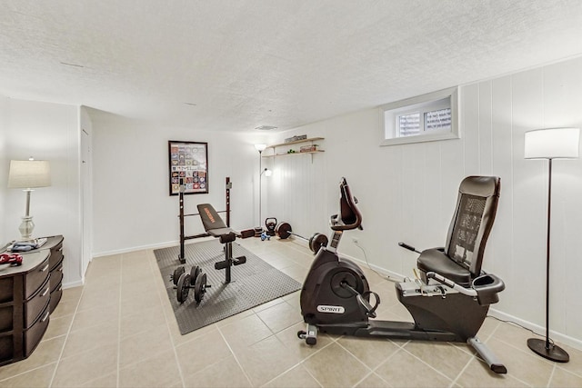 workout room featuring light tile patterned floors and a textured ceiling