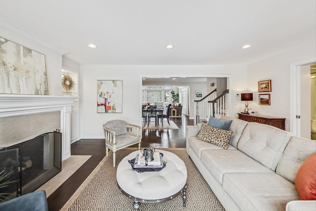 living area featuring a fireplace with flush hearth, recessed lighting, stairs, and dark wood-style floors