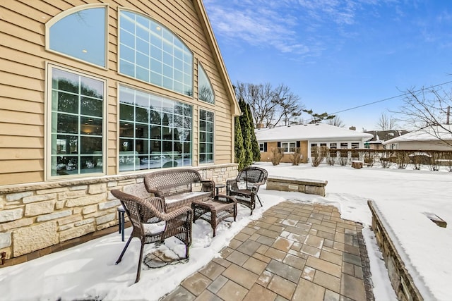 snow covered patio with an outdoor living space