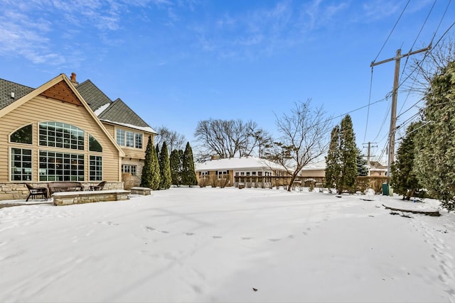 view of snow covered back of property