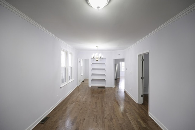 interior space featuring ornamental molding, dark wood-type flooring, and a chandelier