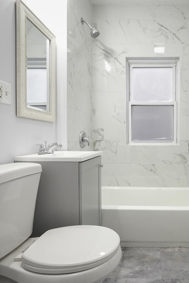 full bathroom with vanity, tiled shower / bath, and toilet