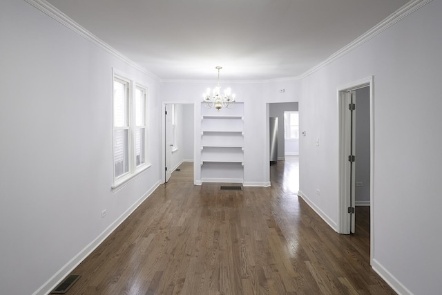 unfurnished dining area featuring crown molding, a healthy amount of sunlight, an inviting chandelier, and dark hardwood / wood-style floors