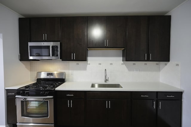 kitchen with stainless steel appliances, sink, dark brown cabinetry, and decorative backsplash