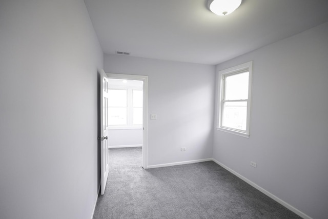 unfurnished room featuring dark colored carpet