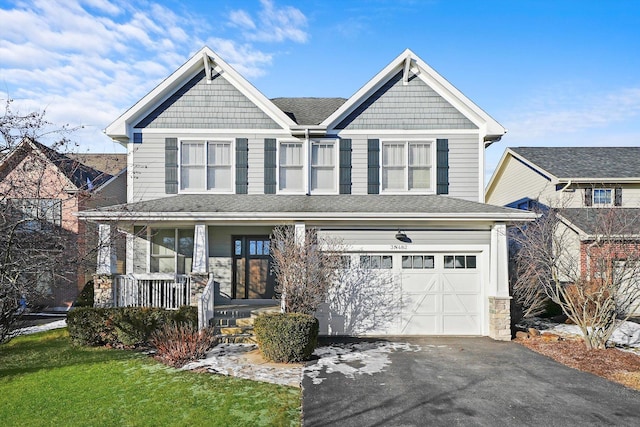 view of front facade with a garage, a front yard, and covered porch