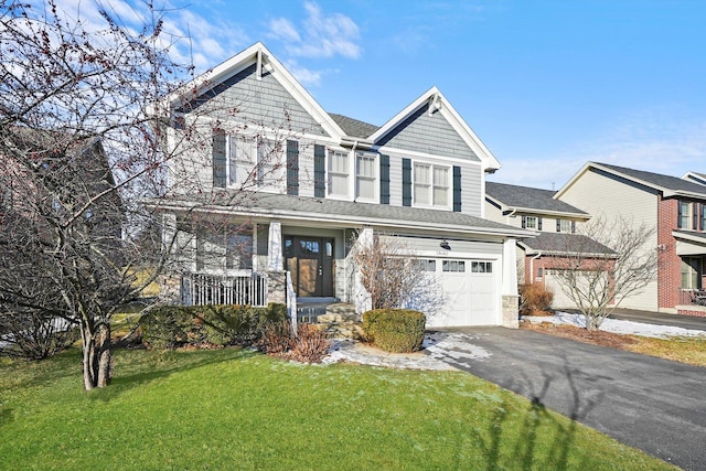 view of front of property with a garage, a front yard, and covered porch