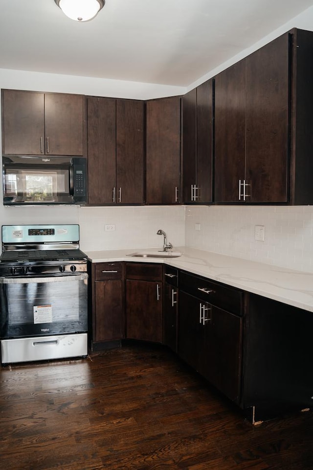 kitchen with stainless steel gas range oven, sink, and dark brown cabinetry