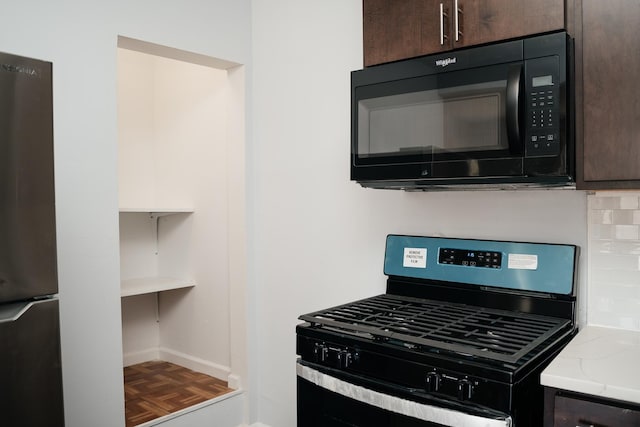 kitchen featuring backsplash, dark brown cabinets, light stone counters, black appliances, and parquet floors