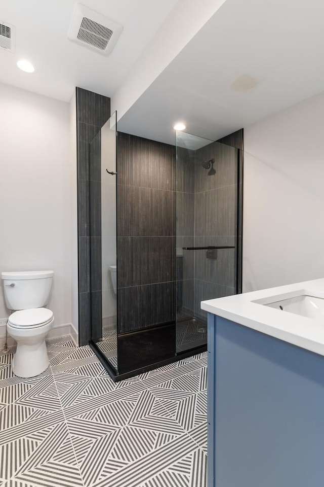 bathroom featuring vanity, an enclosed shower, tile patterned floors, and toilet